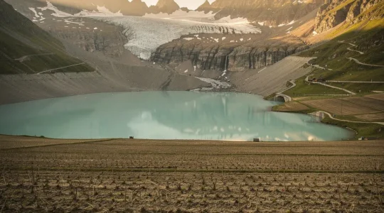 Vue panoramique des Alpes suisses avec glaciers et lacs montrant le paradoxe entre abondance apparente et risques de pénurie